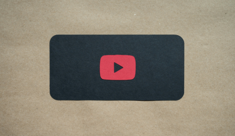YouTube Play Symbol vor beigem Hintergrund