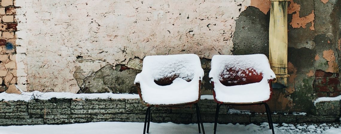 zwei rote Sessel mit Schnee bedeckt