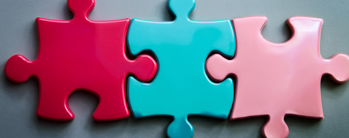 Ein Puzzle in den Parteifarben der aktuellen Bundesregierung - rot, türkis und pink