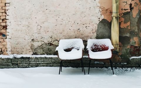 zwei rote Sessel mit Schnee bedeckt